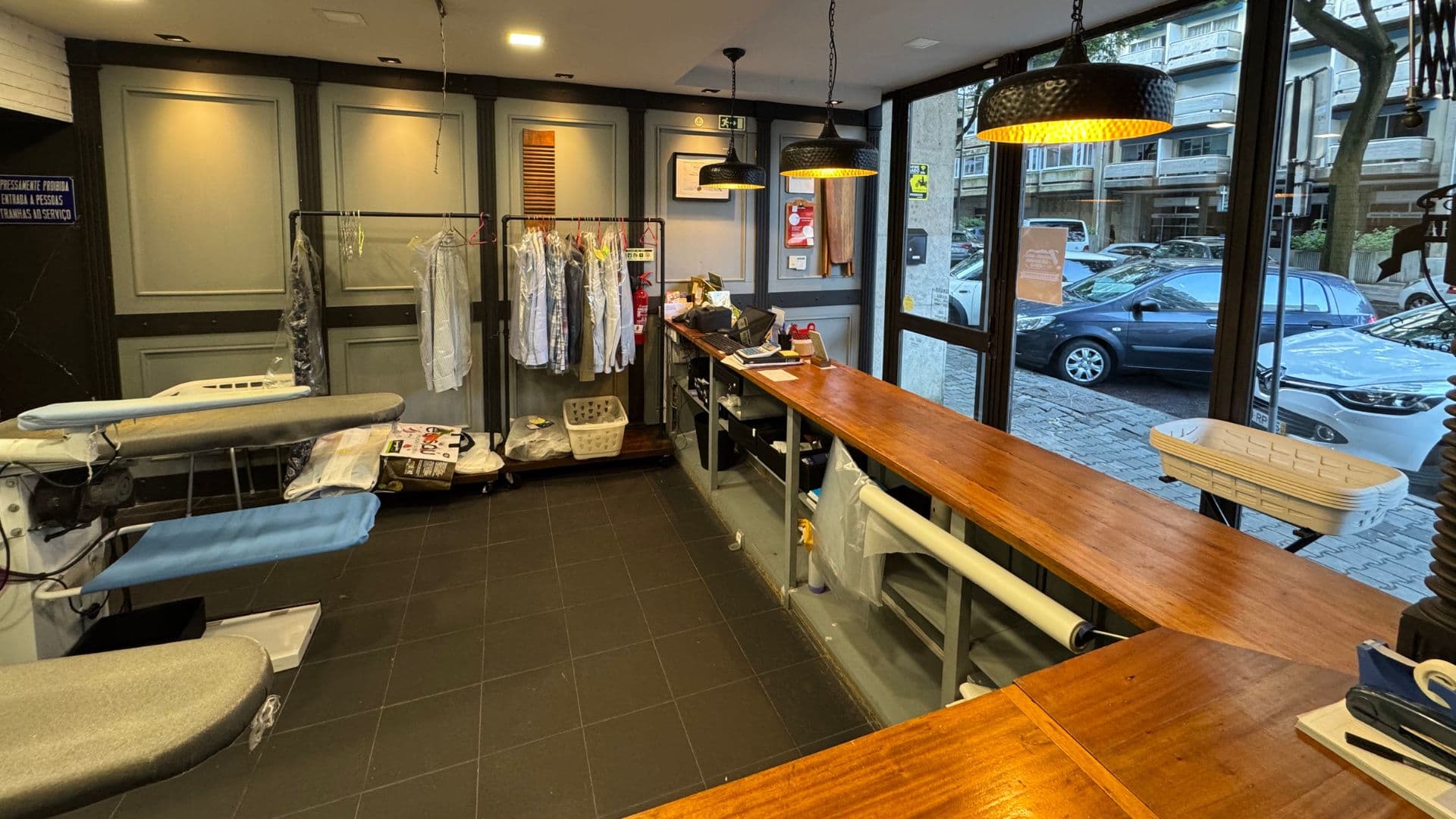 Interior da A Ferraria Engomadoria com balcão de madeira e área de trabalho